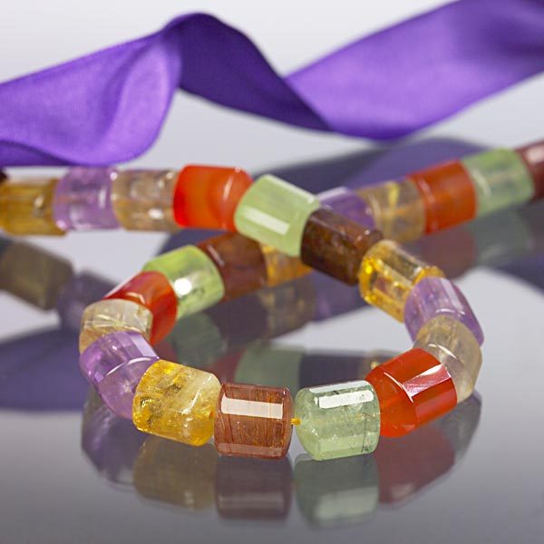 Eine Kette aus verschiedenen Edelsteinen in Zylinderform bunt.jpg